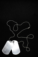 Top view of two blank silver color soldier military tags on ball chain on black background with copy space for text.