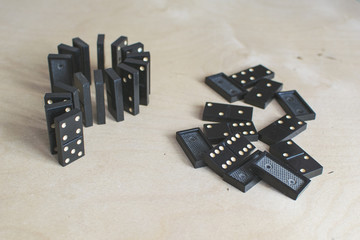 black dominoes on light wooden background