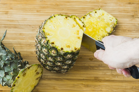 closeup cutting a pineapple on wooden background
