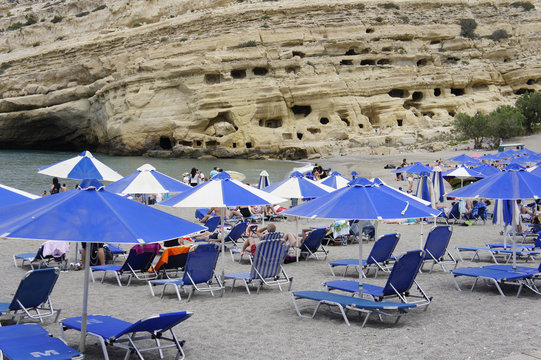 Crete island, Matala, beach with sun loungers and umbrellas in the bay of Messara
