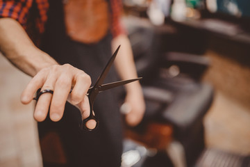 Fototapeta na wymiar Barber shop. Close-up of barber holds clip-on hair clipper barbershop