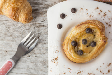 Puff pastry with chocolate on white plate.