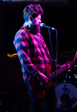Man with enthusiastic face holds guitar, singing song, play music,
