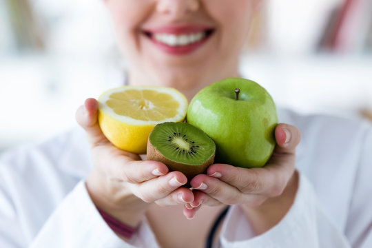 Doctor hands holding fruit such as apple, kiwi and lemon.