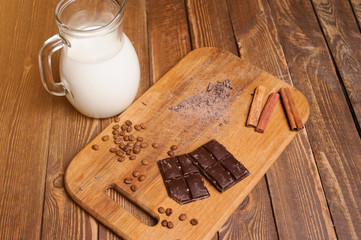 bowl of chocolate ice cream scoops with pieces of chocolate bar and waffle cones on dark background