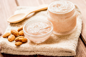 Obraz na płótnie Canvas body scrub with almonds for body care on wooden table background