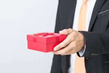 Businessman holds out the gift red box, isolated background