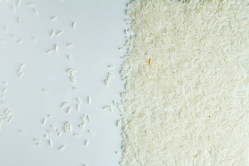 The rice is evenly scattered on a white table.