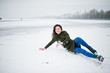 Fototapeta na wymiar Funny girl wear on long green sweatshirt and jeans, at frozen lake in winter day.