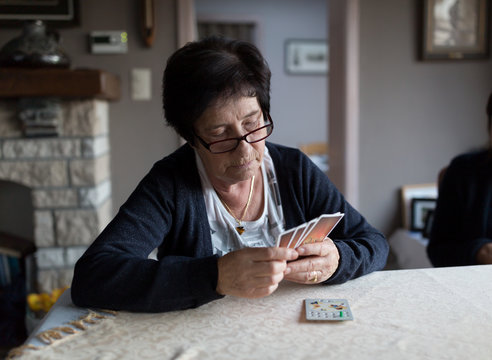 Senior woman holding deck of cards playing card game
