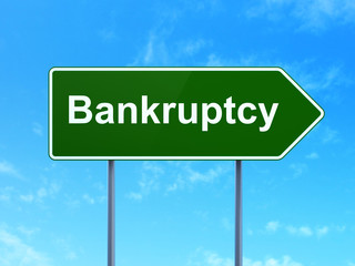 Currency concept: Bankruptcy on green road highway sign, clear blue sky background, 3D rendering