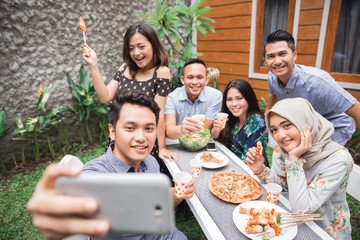 friends barbecue at outdoor and  taking selfie together