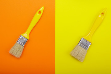 Two Yellow paintbrush on orange end yellow background