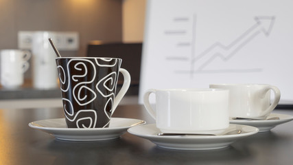 White coffee cups and a black and white tea mug standing on a sideboard in a conference room in...