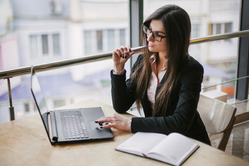 pensive brunette is holding a pen