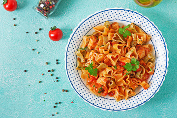Pasta in the shape of hearts with chicken and tomatoes in tomato sauce. Top view