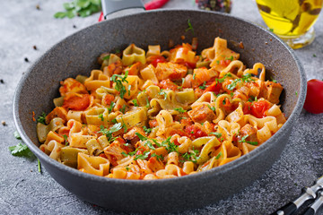 Pasta in the shape of hearts with chicken and tomatoes in tomato sauce.