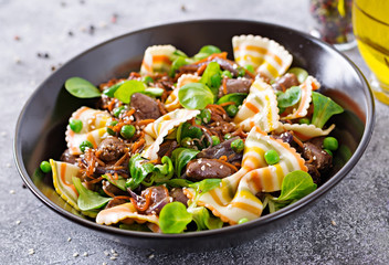 Chicken hearts with carrots in sweet and sour sauce with farfalle pasta. Healthy salad