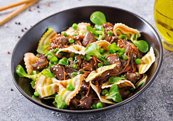Chicken hearts with carrots in sweet and sour sauce with farfalle pasta. Healthy salad