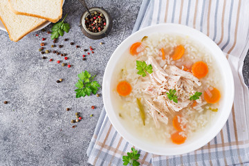 Dietary chicken soup with rice and carrots. Healthy food. Flat lay. Top view