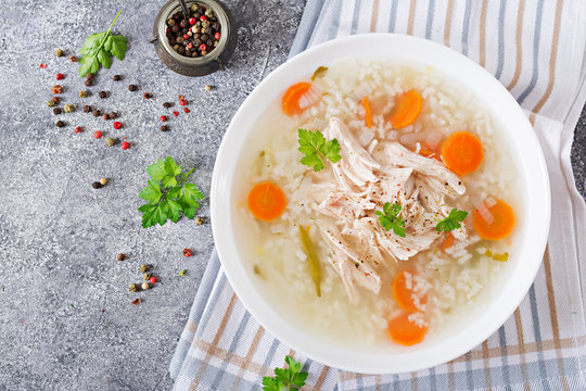Dietary chicken soup with rice and carrots. Healthy food. Flat lay. Top view