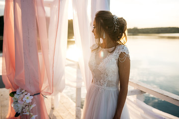 Beautiful bride standing at sunset