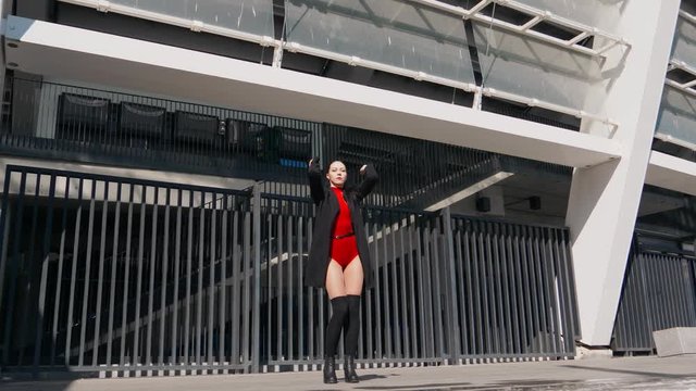 Sexy female dancer in Vogue and Waacking dance style dancing in the city with urban background.