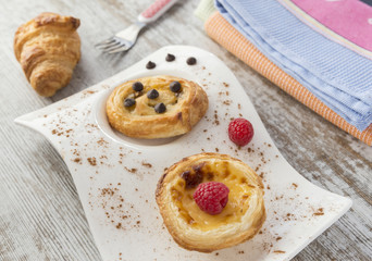 Cream cake and puff pastry with raspberries and chocolate. Croissant.