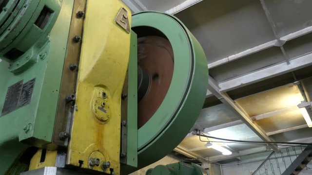Rotating a big flywheel in a workshop at a plant.
