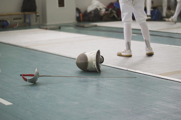 Rapier and protective mask on the flour during fencing competitions