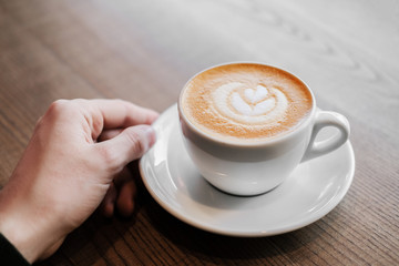 man holding a cappuccino cup