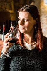 beautiful woman drinking glass of wina in a wine cellar