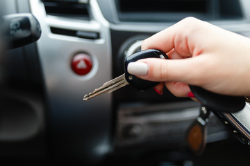 Car keys in the hand of a girl in the car interior. Woman holding car keys. Close up Hand
