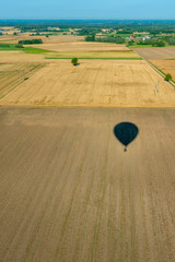 Cień balonu lecącego nad polami z widokiem na horyzont. - obrazy, fototapety, plakaty