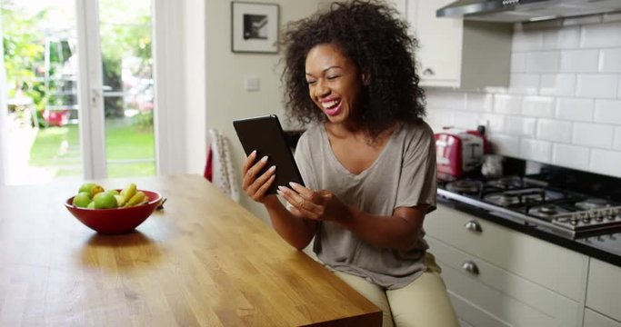 An attractive woman video chats on a digital tablet