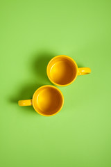 Colorful tea or coffee cups on green background