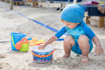 beautiful child plays at the sandy beach during the day