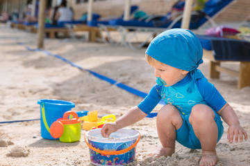 beautiful child plays at the sandy beach during the day
