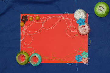 Red frame with tangles of knitting threads on blue background