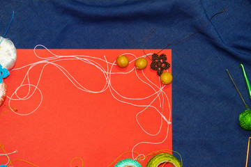 Red frame with tangles of knitting threads on blue background