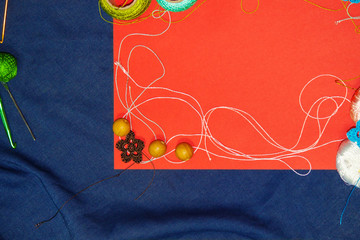 Red frame with tangles of knitting threads on blue background