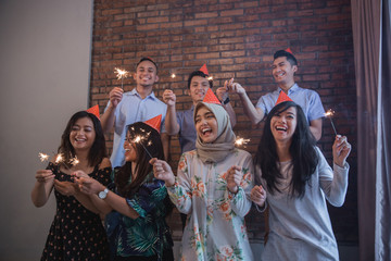  friends lighting sparklers together. celebrating
