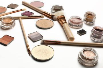 Set of makeup brushes, highlighter,cream eyeshadow, brow gel on a white background