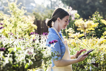 Female employee of garden center nursery texting