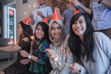 Fototapeta premium friends lighting sparklers together. celebrating