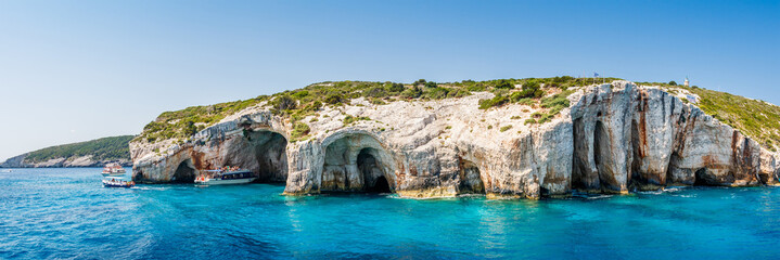 Tourist boats close to Blue caves at the cliff of Zakynthos island with, Greece, Panorama view