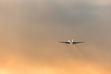 Fototapeta na wymiar Silhouette of airplane taking off during a dramatic sunset sky, copy space. Aviation. 