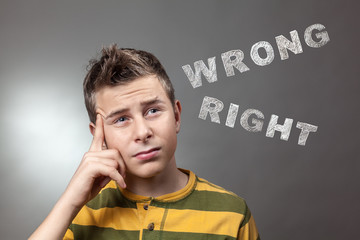 Young boy looking up at wrong and right words