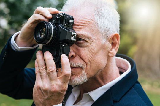 Mature man taking pictures, light effect