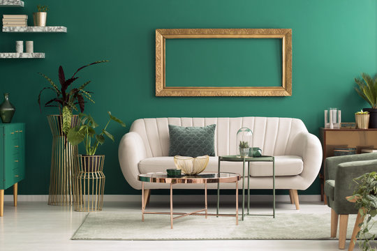 Beige sofa in green interior